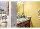 Small powder room with single sink vanity, granite countertop, and yellow walls at 31211 Gossamer Way, Wesley Chapel, FL 33543