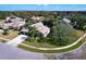 Aerial view of a home with lush landscaping, a circular driveway, and a screened in pool at 335 Palmdale Dr, Oldsmar, FL 34677