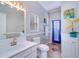 Charming bathroom featuring decorative mirror, tile floors, and a bright blue door to the pool at 335 Palmdale Dr, Oldsmar, FL 34677