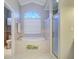 Soaking tub in bathroom with tiled surround, large window, and glass-enclosed shower at 335 Palmdale Dr, Oldsmar, FL 34677