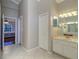 Hallway view to bathroom and bedroom with tile flooring and large mirror at 335 Palmdale Dr, Oldsmar, FL 34677