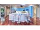 Bright kitchen features an island with bar seating, stainless steel appliances, and blue cabinets at 335 Palmdale Dr, Oldsmar, FL 34677