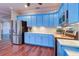 Well-lit kitchen with stainless steel appliances, blue cabinetry, and wood flooring at 335 Palmdale Dr, Oldsmar, FL 34677