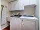Laundry room features modern washer and dryer, sink, and white cabinetry at 335 Palmdale Dr, Oldsmar, FL 34677