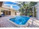 A beautiful screened-in pool area with a waterfall feature and brick paved patio at 335 Palmdale Dr, Oldsmar, FL 34677