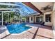 A beautiful screened-in pool area with a waterfall feature and brick paved patio at 335 Palmdale Dr, Oldsmar, FL 34677