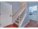 Carpeted staircase with white railing, wood flooring, and view into the laundry room at 335 Palmdale Dr, Oldsmar, FL 34677