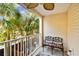 Relaxing balcony features a wrought iron bench and a ceiling fan at 3629 Gulf Blvd, St Pete Beach, FL 33706