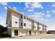 Modern three-story building with garages and green doors at 3629 Gulf Blvd, St Pete Beach, FL 33706