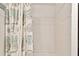 Shower stall with a white tile surround and sand dollar shower curtain at 3629 Gulf Blvd, St Pete Beach, FL 33706