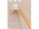 Elegant staircase with light beige carpeting and a wood handrail at 3629 Gulf Blvd, St Pete Beach, FL 33706