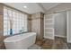 Elegant bathroom with soaking tub, walk-in shower, and barn door at 5052 Florentine Ct, Spring Hill, FL 34608