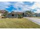 House exterior with a large front yard and landscaping at 5052 Florentine Ct, Spring Hill, FL 34608