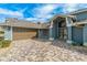 Attractive house exterior featuring a paver driveway and landscaping at 5052 Florentine Ct, Spring Hill, FL 34608