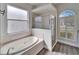 Bathroom with soaking tub, walk-in shower, and window at 5206 Whispering Leaf Trl, Valrico, FL 33596