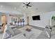 Spacious living room with vaulted ceilings, gray sectional sofa, and large TV at 5206 Whispering Leaf Trl, Valrico, FL 33596