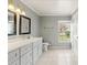 Bathroom with gray vanity, double sinks, and tiled floor at 5332 Nutcracker Cir, Land O Lakes, FL 34639