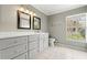 Bathroom with gray vanity, double sinks, and tiled floor at 5332 Nutcracker Cir, Land O Lakes, FL 34639