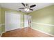 Bedroom with wood floors, ceiling fan, and double closet at 5332 Nutcracker Cir, Land O Lakes, FL 34639