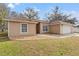 Tan house with a brown roof, white garage door and well-manicured lawn at 5332 Nutcracker Cir, Land O Lakes, FL 34639