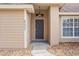 Gray front door with a light fixture, and stone walkway at 5332 Nutcracker Cir, Land O Lakes, FL 34639