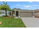 One-story house with attached garage, landscaped lawn, and palm trees at 5809 War Admiral Dr, Wesley Chapel, FL 33544