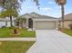 Tan one-story house with two-car garage at 5809 War Admiral Dr, Wesley Chapel, FL 33544