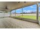 Screened patio with tiled floor, ceiling fan and backyard access at 5809 War Admiral Dr, Wesley Chapel, FL 33544