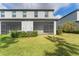 Home's backyard with grassy area and screened patio at 7227 Sweet Alyssum Ct, Tampa, FL 33619
