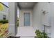Front entry with blue door and small porch at 7227 Sweet Alyssum Ct, Tampa, FL 33619
