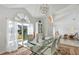Modern glass dining table with white chairs and large window at 10025 Cypress Shadow Ave, Tampa, FL 33647