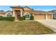 Tan house with three-car garage, lush lawn, and manicured hedges at 10025 Cypress Shadow Ave, Tampa, FL 33647
