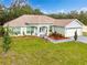 Single-story house with landscaped yard, attached garage, and a neutral color palette at 11421 Petrel Ave, Weeki Wachee, FL 34614