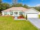 House exterior with a well-maintained lawn and attached garage at 11421 Petrel Ave, Weeki Wachee, FL 34614