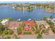 Aerial view of waterfront home with red tile roof, boat dock, and circular driveway at 1818 Dolphin S Blvd, St Petersburg, FL 33707