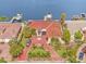 Waterfront property with red tile roof, boat dock, and circular driveway, seen from above at 1818 Dolphin S Blvd, St Petersburg, FL 33707