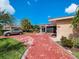 Tan house with red brick driveway, screened entry and a silver car parked at 1818 Dolphin S Blvd, St Petersburg, FL 33707