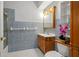 Clean bathroom with light blue tile and wood vanity at 18801 Orange Hill Dr, Hudson, FL 34667