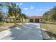House exterior with a long driveway leading to a two-car garage at 18801 Orange Hill Dr, Hudson, FL 34667