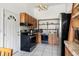 Galley kitchen with black appliances and wood cabinets at 18801 Orange Hill Dr, Hudson, FL 34667