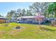 Spacious backyard with lush grass, a stone fountain and mature trees at 21 Belle Meade Cir, Largo, FL 33770