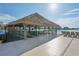 Relaxing tiki bar with thatched roof and barstools by the lagoon at 32241 Turtle Grace Loop, Wesley Chapel, FL 33545