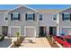 Gray townhome with two-car garage and landscaped front yard at 32241 Turtle Grace Loop, Wesley Chapel, FL 33545