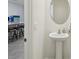 Modern powder room with pedestal sink and round mirror at 32241 Turtle Grace Loop, Wesley Chapel, FL 33545