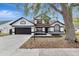 Two-story house with a dark brown and white exterior, landscaping, and a driveway at 3404 Shady Brook Ln, Sarasota, FL 34243