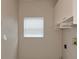 Simple laundry room with overhead cabinets and a window for natural light at 3404 Shady Brook Ln, Sarasota, FL 34243