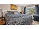 King bedroom with patterned comforter and guitar at 355 Moorings Cove Dr # 355, Tarpon Springs, FL 34689