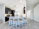 Kitchen island with granite countertop and four white stools at 5629 Maidenstone Way, Palmetto, FL 34221