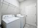 Bright laundry room with washer, dryer, and overhead shelving at 5629 Maidenstone Way, Palmetto, FL 34221