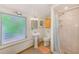Bathroom with pedestal sink, shower, and a window at 604 Pennsylvania Ave, Crystal Beach, FL 34681